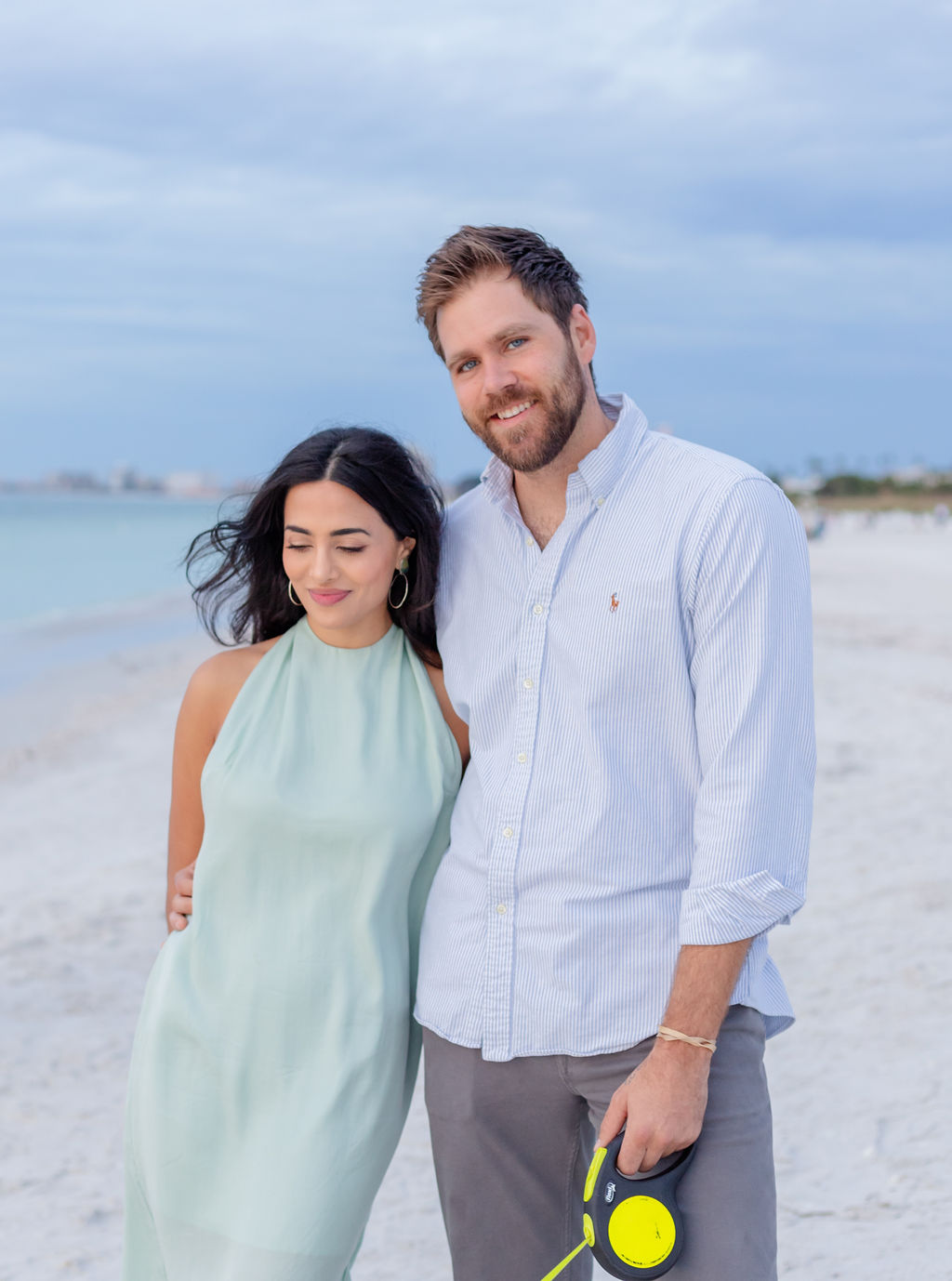 A couple at a beach portrait candid hugging light and bright style