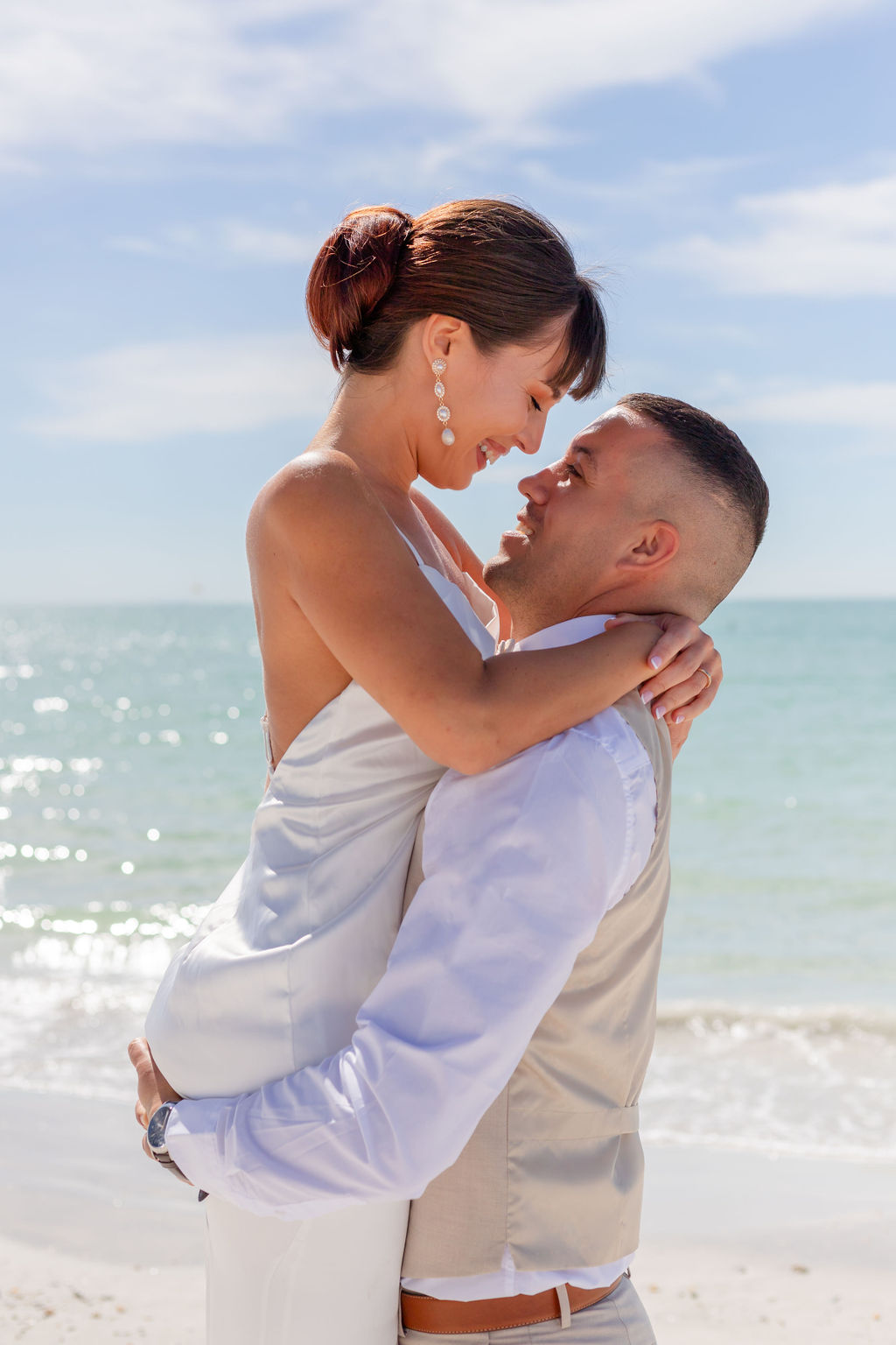 beach wedding couple hugging and smiling