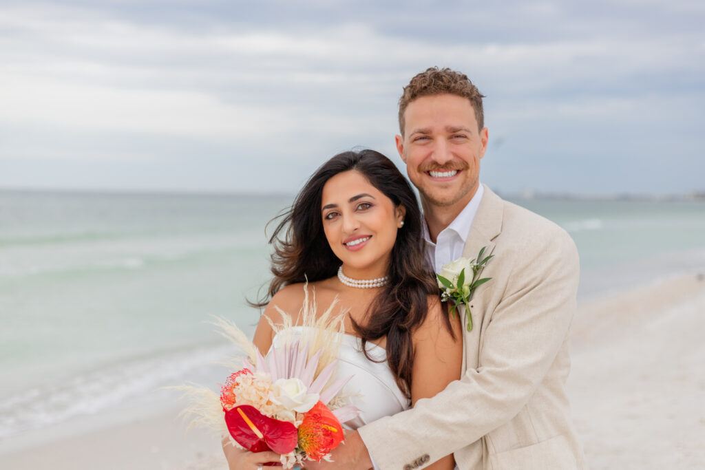 Siddhi and Zach smiling together on the beach 