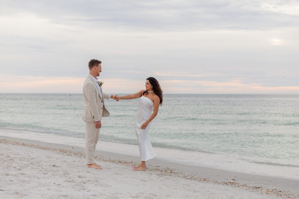 Wedding couple sharing a romantic dancing moment during sunset at the beach