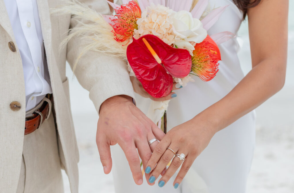 wedding rings and flower bucket at beach wedding