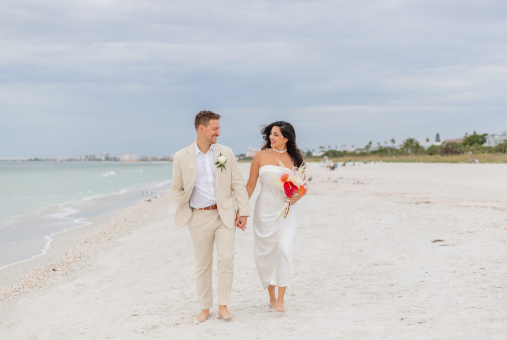 Siddhi and Zach walking and smiling together on the beach 